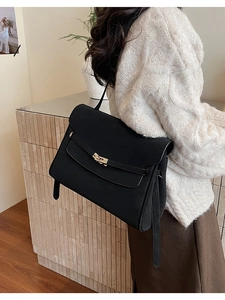 Side view of large black vintage briefcase with gold buckle on a shoulder strap