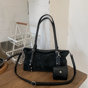 Detail of black matte suede tote bag with silver rivets and matching small pouch bag