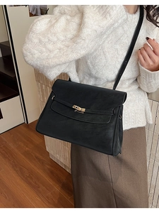 Side view of black matte leather briefcase bag with golden twist lock on a model