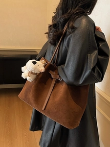 Borsa tote minimalista in pelle scamosciata marrone scuro con sottili manici e ciondolo