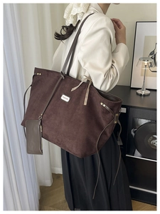 Detail of suede large tote bag with metal Fashion logo and matching small coin purse