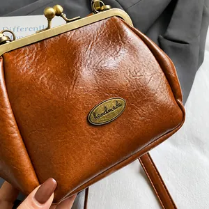 Détail macro d'un sac coquille en similicuir marron avec fermoir métallique vintage fait main