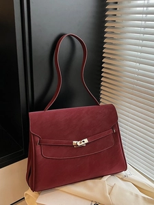 Vintage burgundy leather tote bag with elegant metal clasp and long shoulder strap