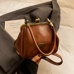 Gros plan sac vintage marron texture cuir avec fermoir doré et emblème fait main