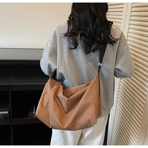 Macro detail of the large capacity brown plaid tote bag with durable canvas strap