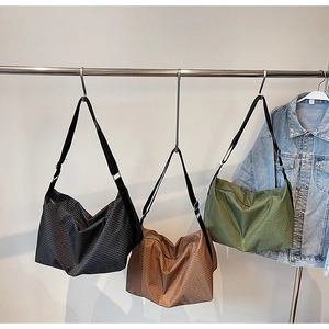 Three oversized plaid tote bags in black, brown, and green with wide shoulder straps