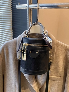 Chic black quilted cylinder bucket bag with heart-print scarf handle and gold hardware