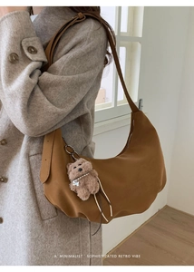 Sac hobo marron en suédine avec breloque ours et bandoulière porté par mannequin