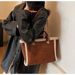 Detail of vintage brown suede tote bag with white faux fur trim and gold chain strap