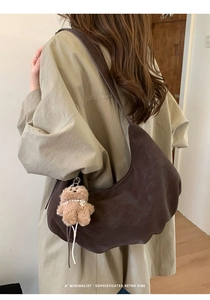 Détail du sac hobo minimaliste marron foncé avec un pendentif ours en peluche