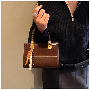 Close-up of leopard print handbag with woven handle and ethnic beaded tassel charm