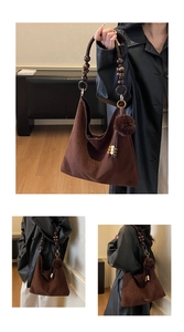 Detail of coffee brown suede hobo bag with decorative wooden bead shoulder strap