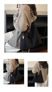 Close-up of black suede tote bag featuring unique wooden bead handle and furry ball detail