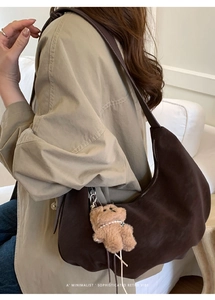 Détail du sac hobo en daim marron avec bandoulière réglable et pendentif ours en peluche