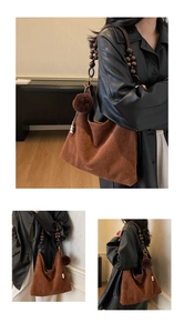 Detail of a brown suede tote bag featuring a decorative wooden beaded shoulder strap