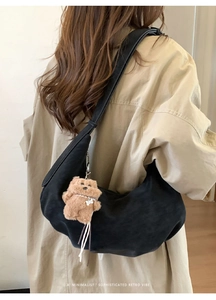 Vue arrière du sac croissant en daim noir avec un petit pendentif ours en peluche