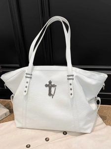 White vintage punk tote bag with bronze cross pendant and star studs on black background