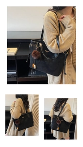 Detail of black matte tote bag with drawstring, gold logo and plush charm accessory