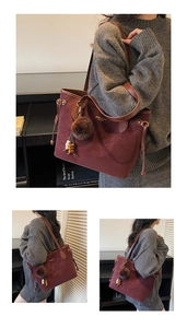 Detail of burgundy suede tote bag with leather handles and decorative tassel ornament