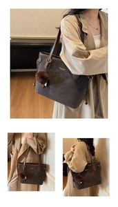 Detail of dark brown suede tote bag with plush charm and golden logo for daily commute