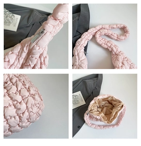 Detalle del bolso acolchado rosa con costuras reforzadas y cierre de cremallera metálica