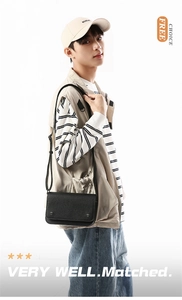 Detail shot of a black leather crossbody bag with silver studs worn by a model