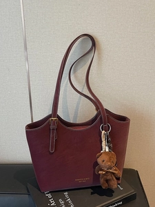 Vintage burgundy faux leather tote bag with gold brand lettering and a cute bear charm