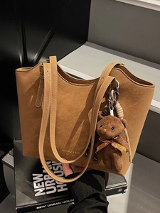 Vintage brown leather tote bag with bear charm and adjustable strap for commuting