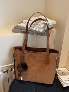 Brown faux suede tote bag with plush charm and minimalist brand logo detail