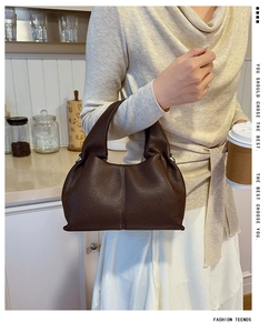 Close-up of dark brown lychee leather hobo bag with wide handle and pleated texture