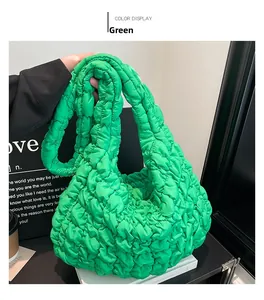 Detalle del bolso de nube acolchado verde con textura suave y costuras fruncidas