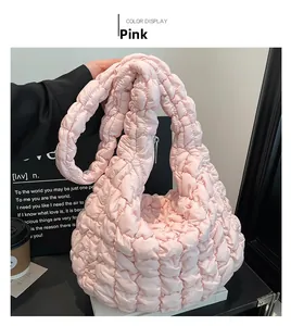 Detalle de bolso nube rosa acolchado con textura fruncida y correa suave para el hombro