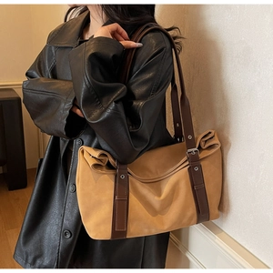 Detail of contrast color tote bag with adjustable brown strap and matte texture