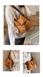 Detail of vintage yellow bucket bag with brown straps and cute grey rabbit plush charm