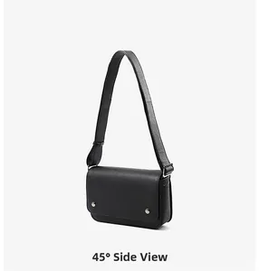 45-degree side view of a minimalist black leather crossbody bag with silver studs