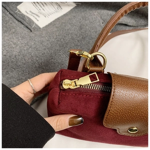 Detail of burgundy suede and brown leather拼接 texture with premium gold zipper