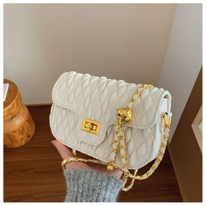 Detail of white quilted crossbody bag with golden metal chain and twist-lock closure