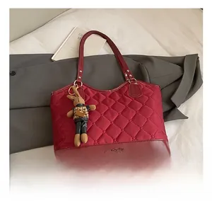 Détail d'un sac cabas matelassé rouge avec breloque lapin et texte Fashion Bag sur nylon