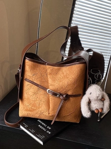 Vintage caramel pleated bucket bag with plush bunny charm and brown shoulder strap