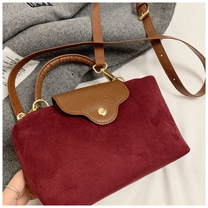 Close-up of retro burgundy velvet texture with brown leather strap and gold hardware