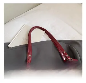 Détail du sac cabas matelassé bordeaux avec poignées renforcées et boucles métalliques