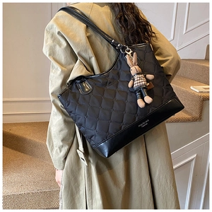 Vue détaillée du grand sac cabas matelassé noir avec breloque lapin sur le mannequin
