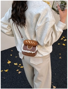 Brown plush bear crossbody bag with lace trim shown on a model in autumn scenery