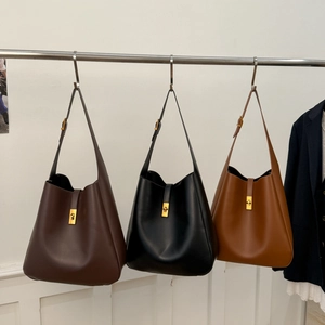 Three large bucket bags in brown, black, and caramel with gold twist lock details