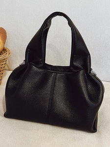 Black pebbled leather cloud hobo bag with top handle and minimalist vertical stitching