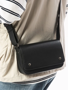 Minimalist black faux leather crossbody bag with lychee texture and silver metal buckles