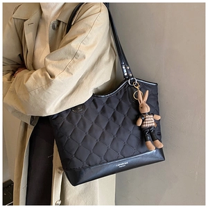 Détail du sac cabas matelassé noir avec motif de losanges et charmant lapin en peluche