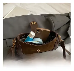 Detail view of the brown vintage crossbody bag showing internal capacity for daily items