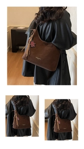 Detailaufnahme der dunkelbraunen Wildleder-Beuteltasche mit Quasten und Bärenanhänger