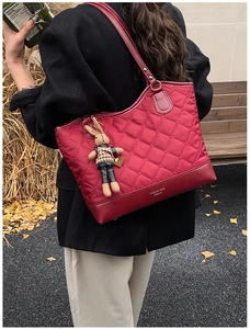 Détail du sac cabas matelassé rouge avec lettrage mode et breloque lapin mignonne